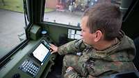 Fahrzeugkran Kabine Ein Soldat sitzt in der Kabine eines Krans