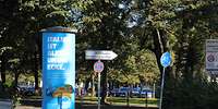Weißes Schild mit Aufschrift Bundeswehrverwaltungszentrum neben Litfaßsäule.