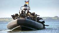 Soldaten fahren in einem Schlauchboot auf einem Gewässer