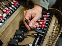 Kabeltasche Die Hand einer Soldatin sortiert Adapter in eine Kabeltasche ein