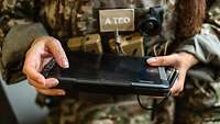 Auslesegerät Eine Soldatin hält ein tabletähnliches Gerät in den Händen