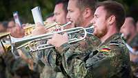Trompeter in deutscher Flecktarnuniform spielen.