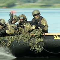 Bewaffnete Soldaten fahren in einem Schlauchboot