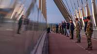 Soldaten stehen auf einer Brücke zu Zweier-Paaren.