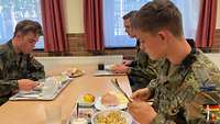 Soldaten der Heimatschutzkompanie Rheinland sitzen beim Essen in der Truppenküche.
