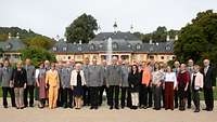 Mehrere Soldaten und ihre Partnerinnen haben sich für ein Gruppenbild vor Schloss Pillnitz versammelt.
