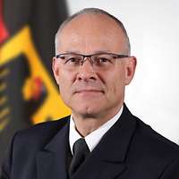 Ein Mann mit Brille in dunkelblauer Uniform