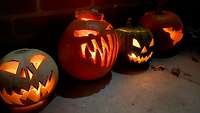 Vier Halloweenkürbisse leuchten. 