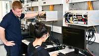 Junge Frau und junger Mann an einem Tisch mit Computer und Messgeräten