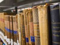 Alte Waelzer Mehrere Bücher liegen im Fokus des Bildes, welche sich nebeneinander in einem Regal befinden.