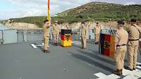Mehrere Soldaten stehen an Oberdeck eines Schiffes 