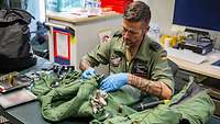 Die Kontrolle der Pilotenausrüstung Ein Soldat kontrolliert die Pilotenausrüstung.