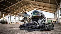 Ein Fliegerhelm liegt auf dem Boden vor einem Eurofighter.