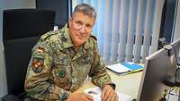 General Laubenthal sitzend am Schreibtisch