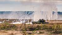 Ein Kampfpanzer Leopard hat Nebel geworfen und entzieht sich so der Sicht der feindlichen Kräfte. 