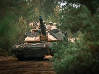 Ein US-Amerikanischer Kampfpanzer Abrams fährt mit hoher Geschwindigkeit durch den Wald