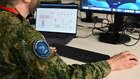 Ein Soldat blickt auf seinen Laptop.