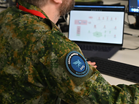 Ein Soldat blickt auf seinen Laptop.