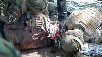 Zwei Soldaten kümmern sich im Freien um eine verletzte Simulationspuppe.