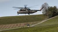 An einem Hubschrauber hängt ein großes Netz.