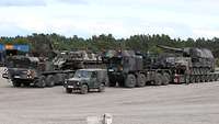 Zwei Schwerlasttransporter haben Panzer aufgeladen.
