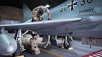 Zwei Soldaten führen Tätigkeiten an einem Eurofighter durch