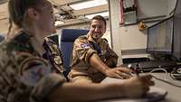 Zwei Soldaten sitzen an einem Computer