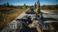 Deutsche und niederländische Soldaten schießen im freien Gelände