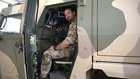 Ein Soldat sitzt auf dem hinteren Sitz eines gepanzerten Fahrzeugs
