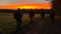 Soldaten laufen auf einem Feldweg.