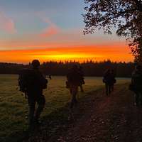 Soldaten laufen auf einem Feldweg.