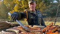 Ein Soldat grillt das MIttagessen.