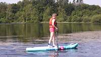 eine Person auf einem Standup Paddle im Wasser