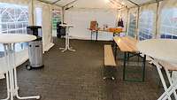 Bierzeltgarnituren, Heizstrahler und Bistrotische in einem Partyzelt