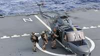 Die letzten drei Personen des Teams steigen auf dem Flugdeck der „Bonn“ in den Hubschrauber des Typs Sea Lynx ein