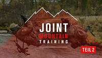 Ein Soldat hängt an einem Seil über einem Gewässer, davor der Schriftzug „Joint Mountain Training – Teil 2“