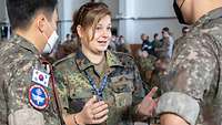 Eine deutsche Soldatin im Gespräch mit zwei südkoreanischen Soldaten