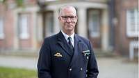 Portraitfoto von Flotillenadmiral Bock vor der Eingang des Hauptgebäudes der Führungsakademie der Bundeswehr