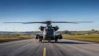 Ein Hubschrauber rollt über eine frisch asphaltierte Landebahn.