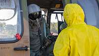 Vorm Ausstieg bekommt der Pilot Instruktionen Der Pilot wird vor dem Aussteigen durch die offene Tür vom ABC-Abwehr-Soldaten befragt.