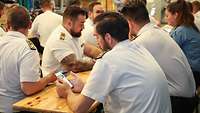 Soldatinnen und Soldaten mit Smartphones an ihren Plätzen.