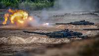 Gefechtsschießen Noble Jump Mehrere Panzer vom Typ Leopard 2 A6 schießen auf einem Truppenübungsplatz, aus einem Rohr strömt ein Feuerball