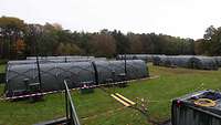 Mehrere Zelte und Container auf einer Wiese