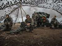 Breakthrough 2021 Deutsche Soldaten schießen mit einer Kanonenhaubitze auf dem Truppenübungsplatz. Rauch strömt aus dem Kanonenrohr.