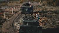 Zwei Panzer, einer mit deutscher und einer mit norwegischer Flagge, fahren einen abgesteckten Weg entlang
