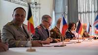 Military Representatives are sitting at a long table