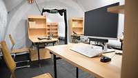 Arbeitsplätze Mehrere Schreibtische mit Computer und Telefon stehen in einem Zelt