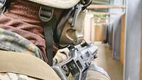 Ein Soldat in Gefechtsausrüstung steht mit seinem Gewehr im Anschlag an einer Tür und beobachtet die Situation.