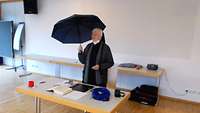 Schwester Irmgard mit einem Regenschirm bei ihrem Vortrag