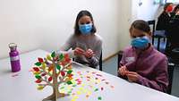 Kinder mit ihren selbst gebastelten Lebensbäumen